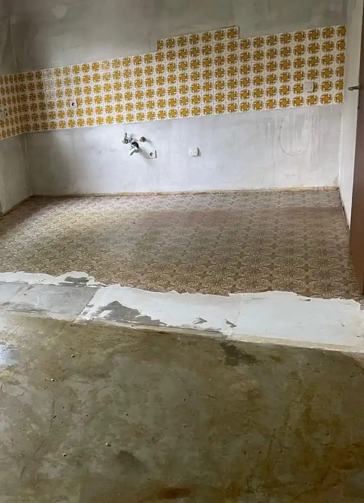 Ausgangslage in Hof: alter PVC-Belag mit Blumenmuster, teils schon aufgenommen, darunter der asbesthaltige Bodenkleber.