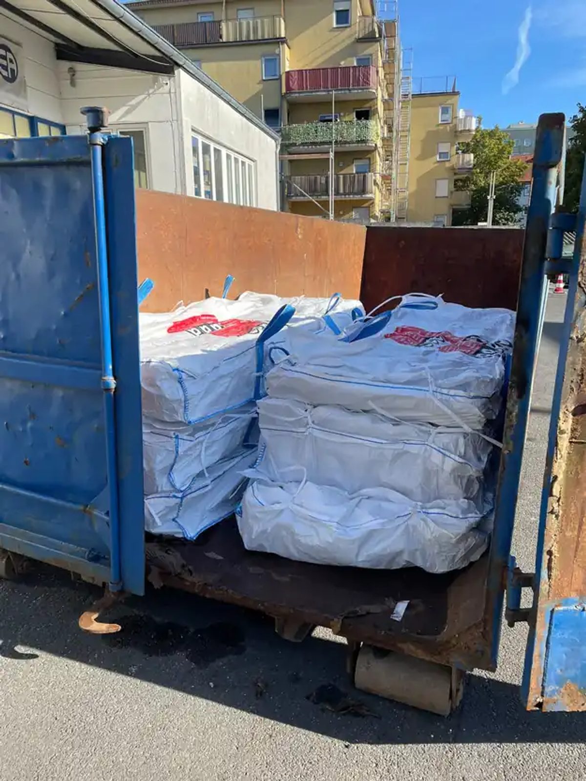 Absetzcontainer an der Straße in Kassel, gefüllt mit verschlossenen und gekennzeichneten Big Bags voller Asbestzement-Wellplatten.
