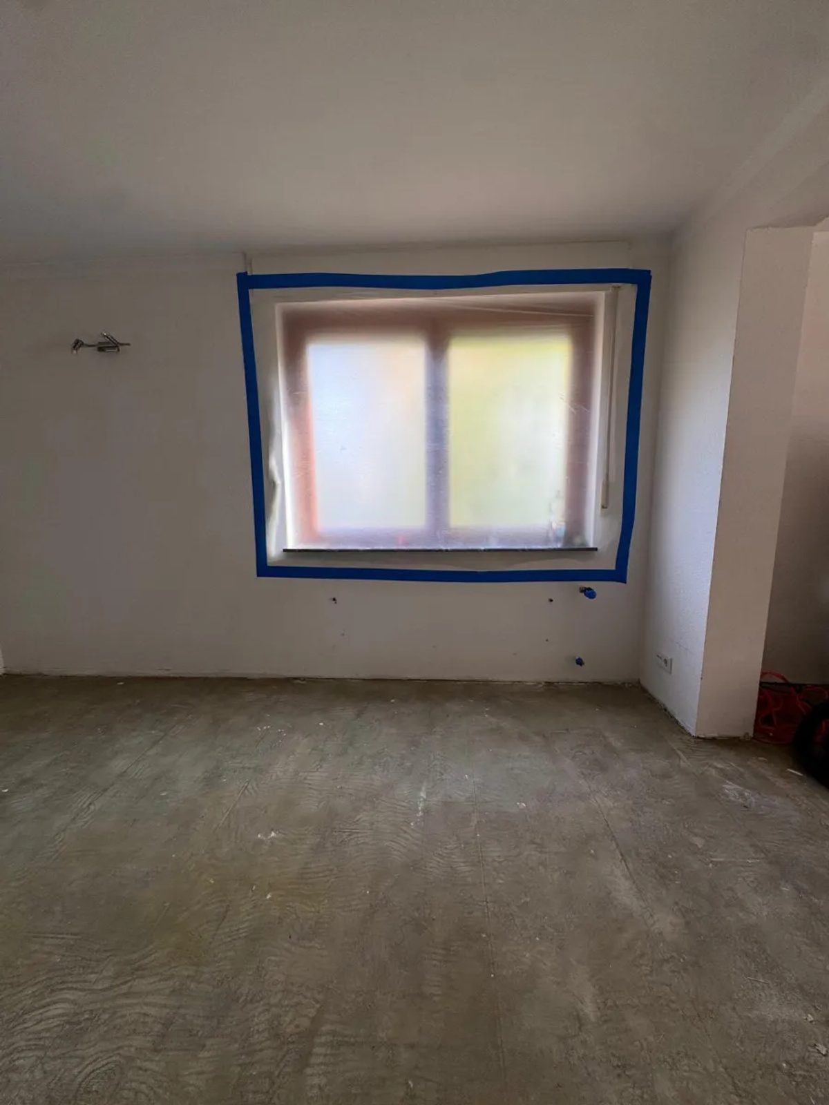 Vorbereiteter Raum in Oberursel: Fenster mit Folie abgeklebt, Wasseranschlüsse verschlossen, Estrich mit asbesthaltigem Kleberbett