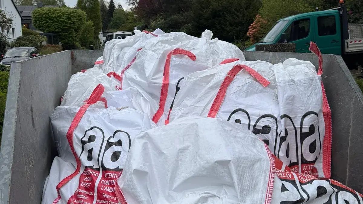 Staubdicht verschlossene Big Bags mit Asbestkennzeichnung in einem Absetzcontainer – so verlässt asbesthaltiger Abfall beider Bindungsklassen die Baustelle.