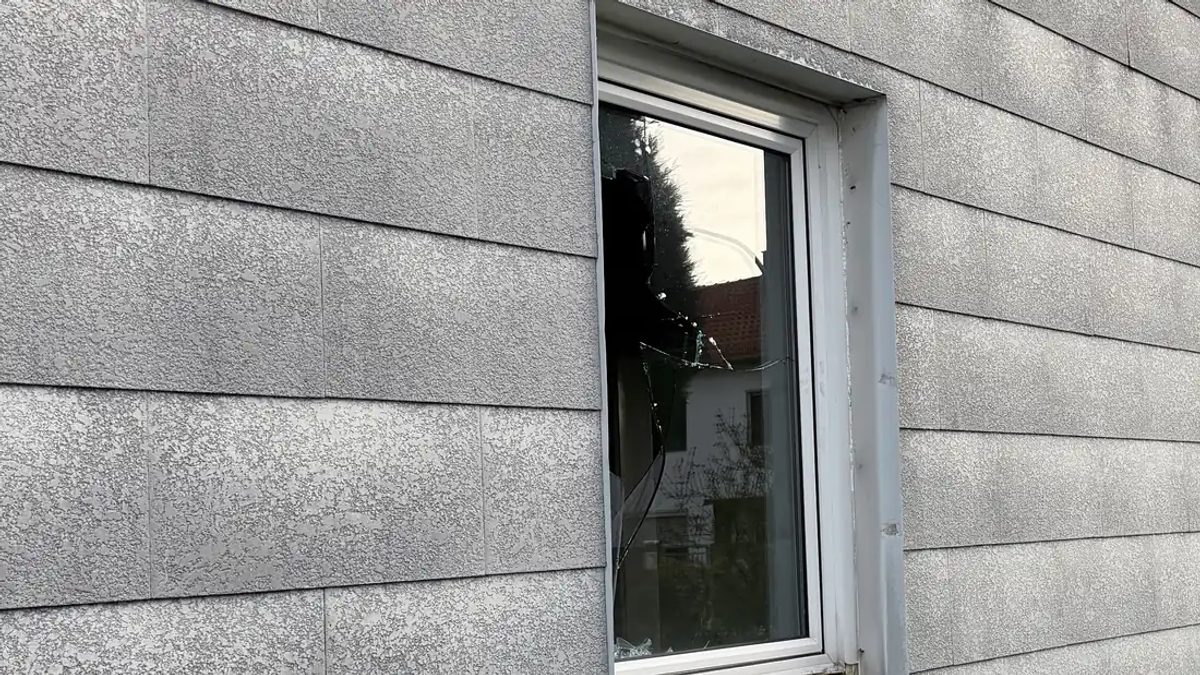 Nahaufnahme verwitterter Asbestzement-Fassadenplatten mit rauer, kreidiger Oberfläche.