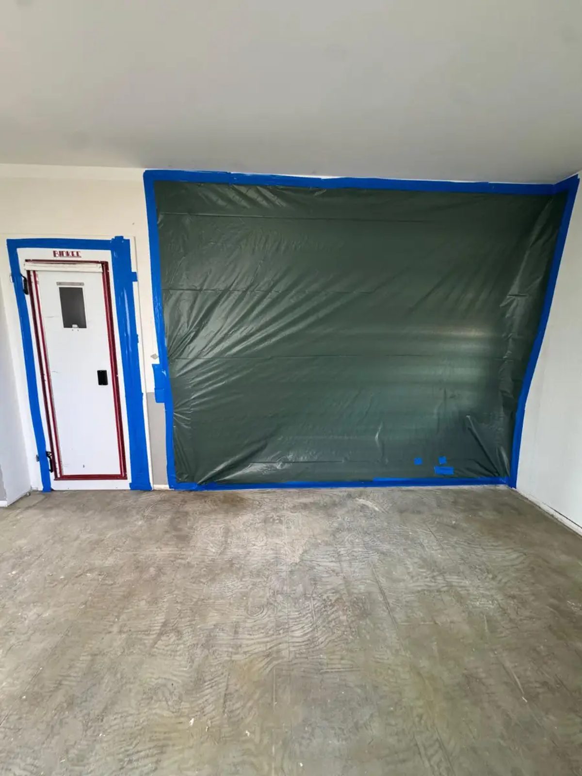 Personenschleuse am Zugang und mit PE-Folie abgeschottete Wand im Sanierungsbereich einer Kernsanierung in Oberursel