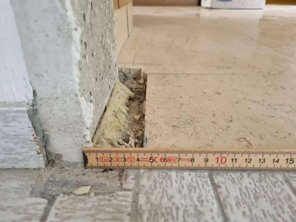 Geöffneter Fußbodenaufbau mit Zollstock: Bodenfliesen, Kleberbett und KMF-Dämmung in einer Küche in Wiesbaden