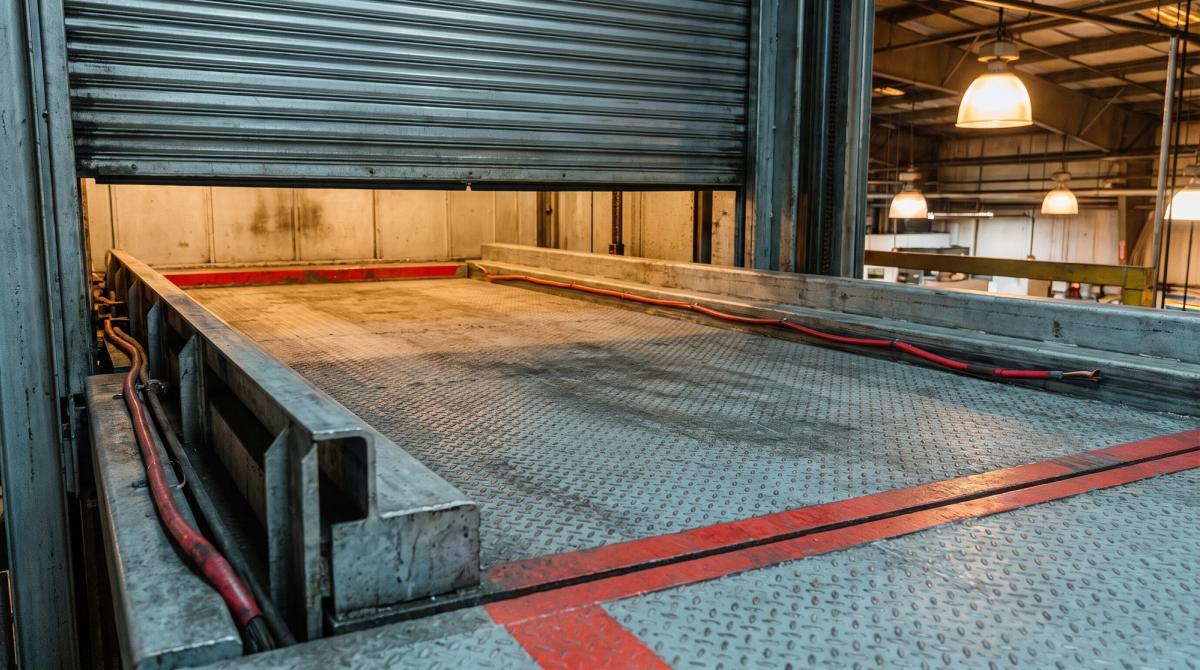 Detail of a car elevator platform with steel floor plate and guide rails