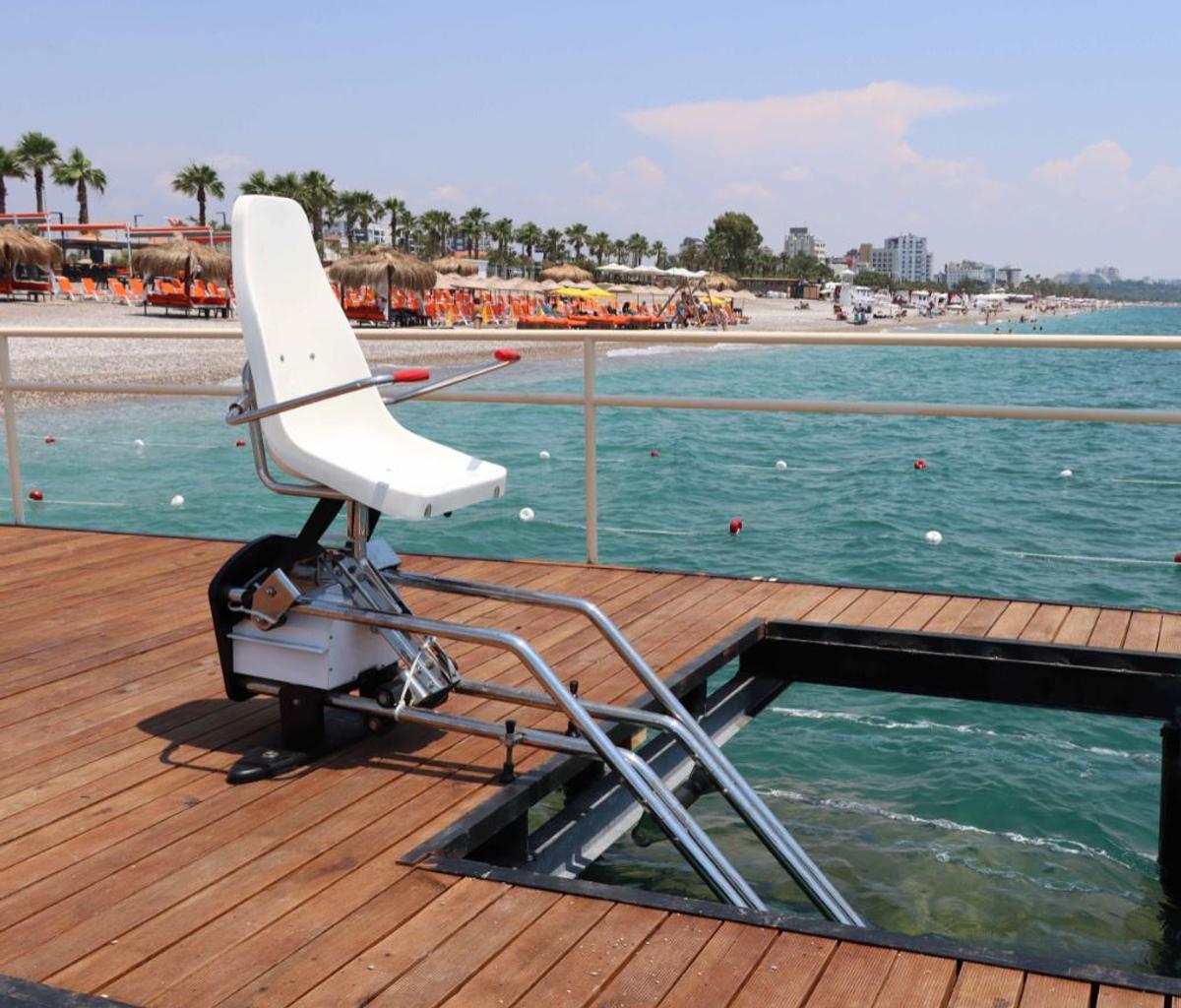 Antalya'da ahşap iskelede deniz erişimi sağlayan koltuklu havuz asansörü