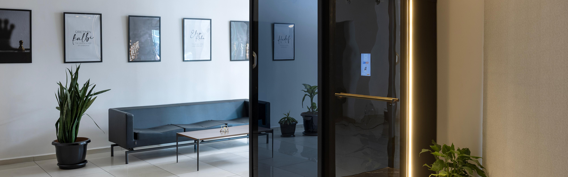 Kanepe ve LED aydınlatmalı asansör kapısı bulunan modern AKE karşılama alanı