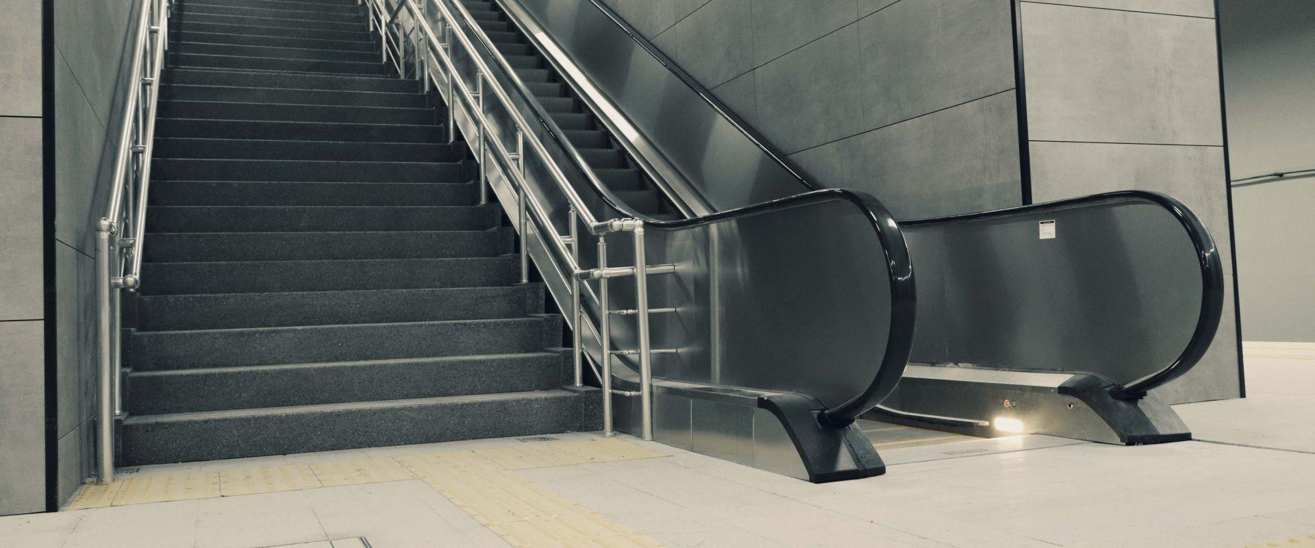 Metro istasyonunda merdiven yanına kurulmuş yürüyen merdiven ve hissedilebilir yürüme yüzeyi