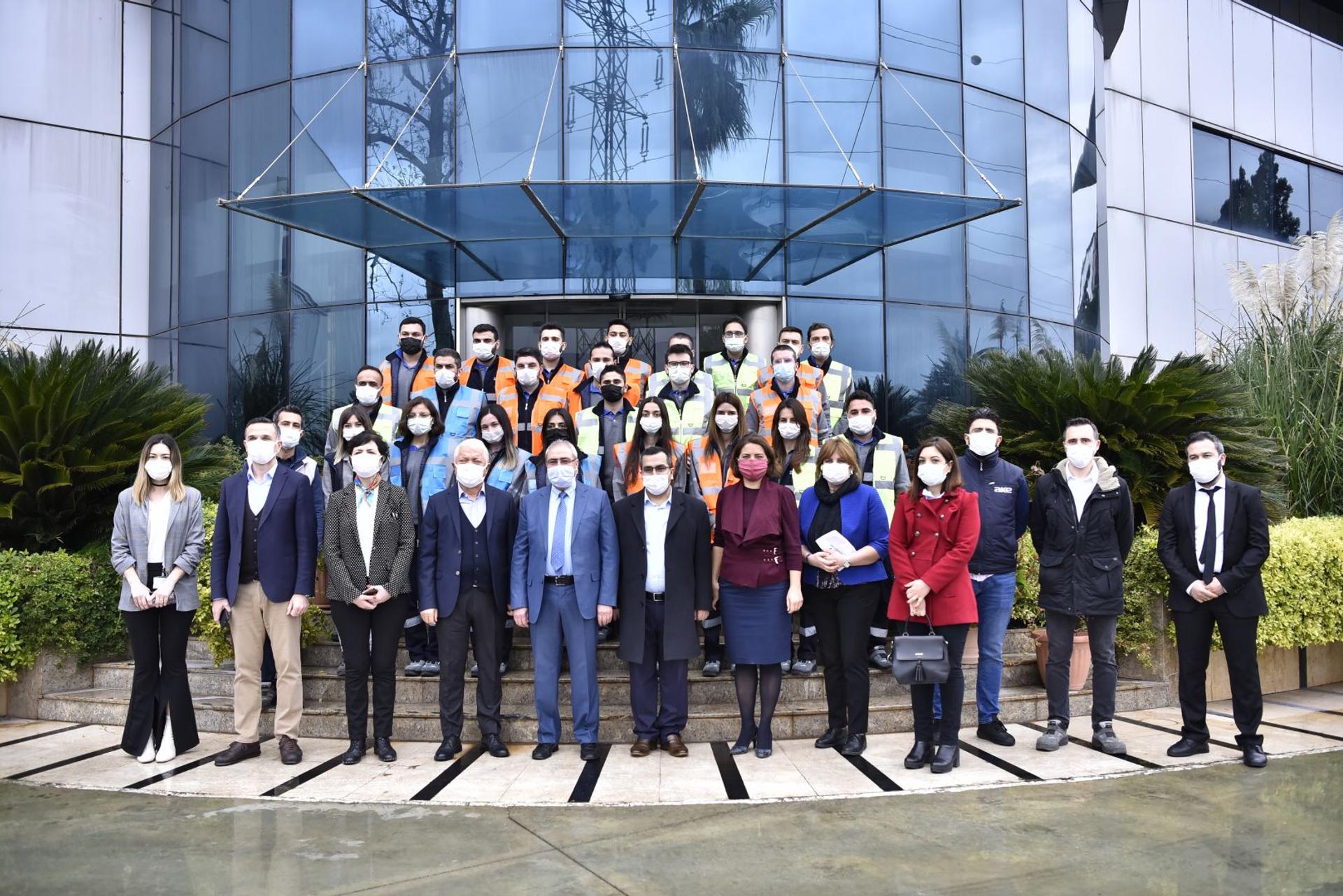 AKE binası önünde iş güvenliği yelekli çalışan ve teknisyenlerden oluşan büyük grup
