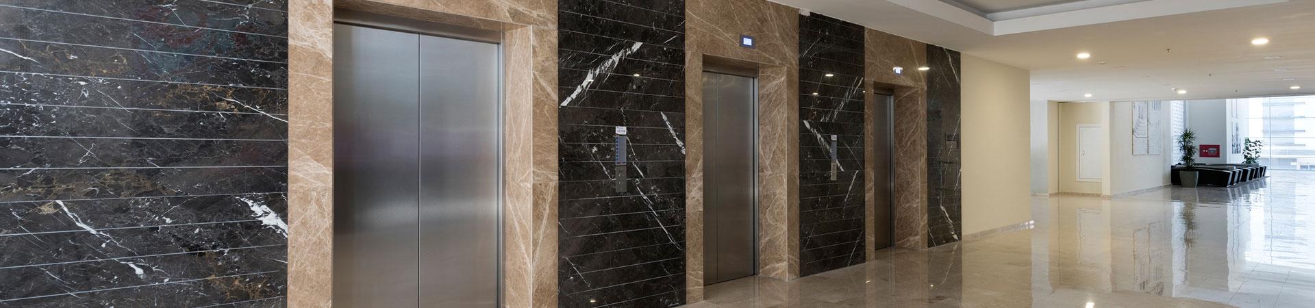 Portes d'ascenseur en inox dans un hall élégant revêtu de marbre
