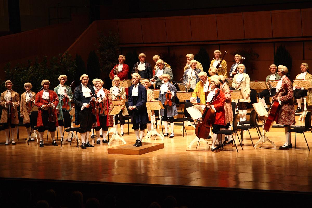 Orchestre et chef en costumes de style XVIIIe siècle sur une scène de concert