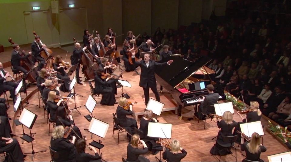 Deux pianistes et un orchestre se produisant sur la scène du Great Amber Concert Hall