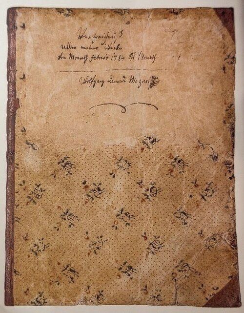 Cubierta decorada y desgastada del catálogo personal de obras de Mozart, con un encabezamiento manuscrito y su nombre