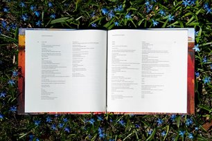 En bok på en seng av blomster og gress