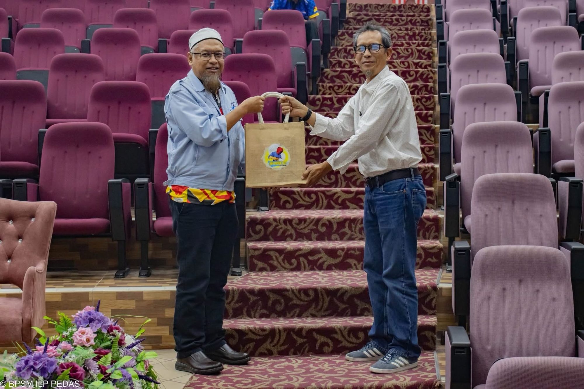 Two programme representatives exchanging an appreciation gift in the ADTEC JTM auditorium