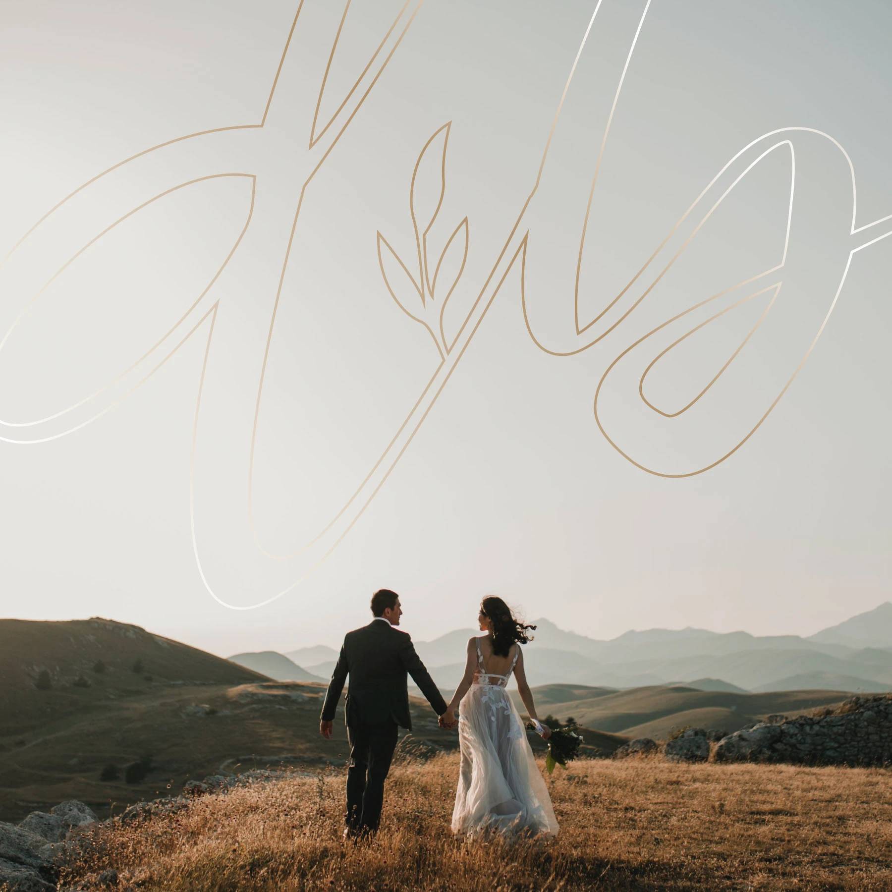 Wedding couple walking through a field beneath the Daniel and Bethany monogram.