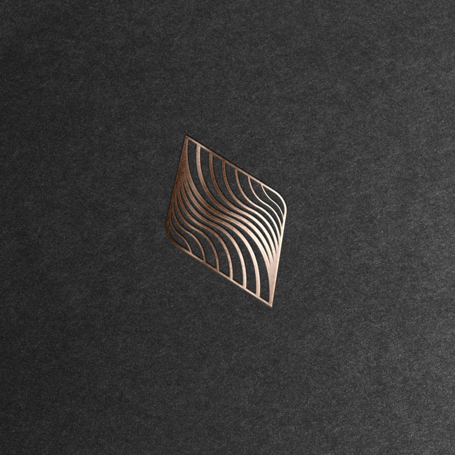 Bronze Okeanos flowing line symbol embossed on dark textured paper.