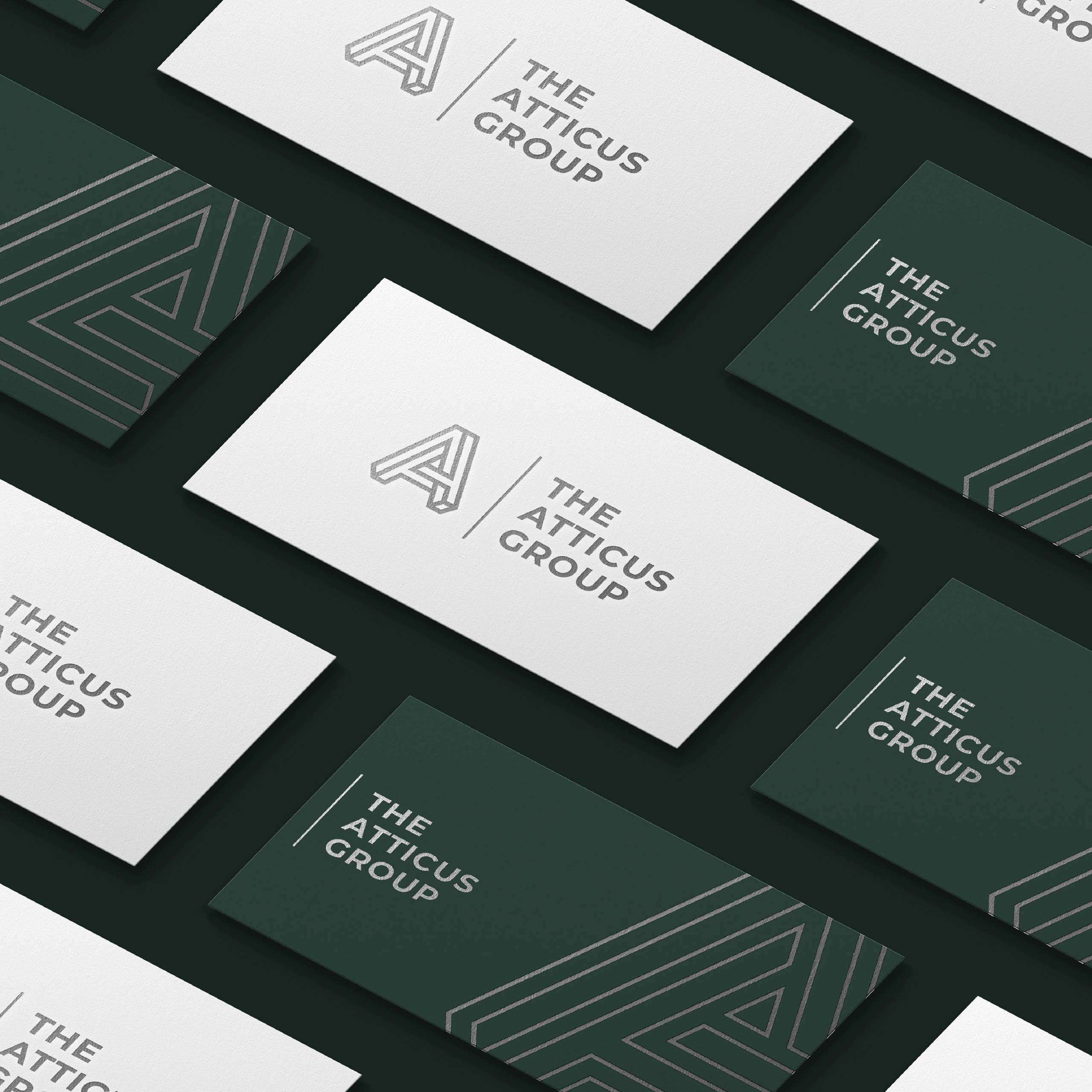 The Atticus Group green and white business cards with geometric A patterns.