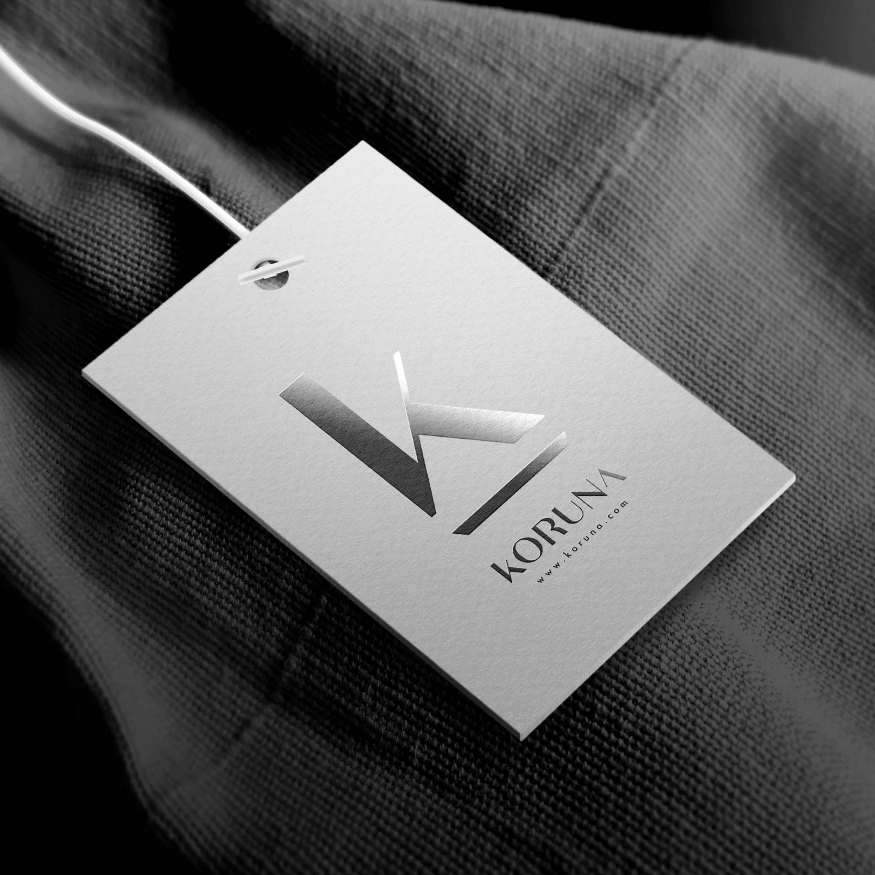 Embossed Koruna angular K monogram and wordmark on a white business card.