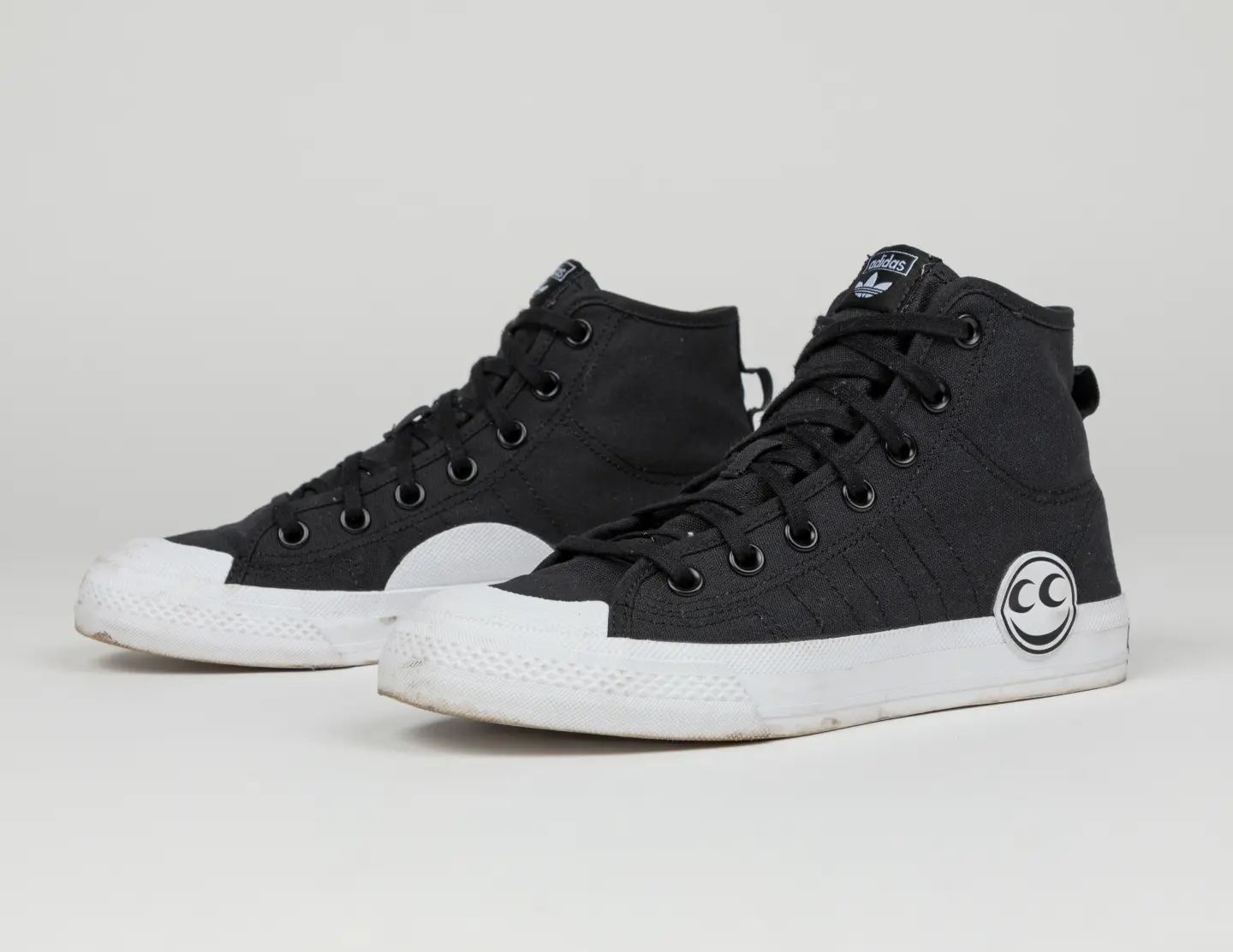 A pair of the black and white See See x Adidas collab shoes