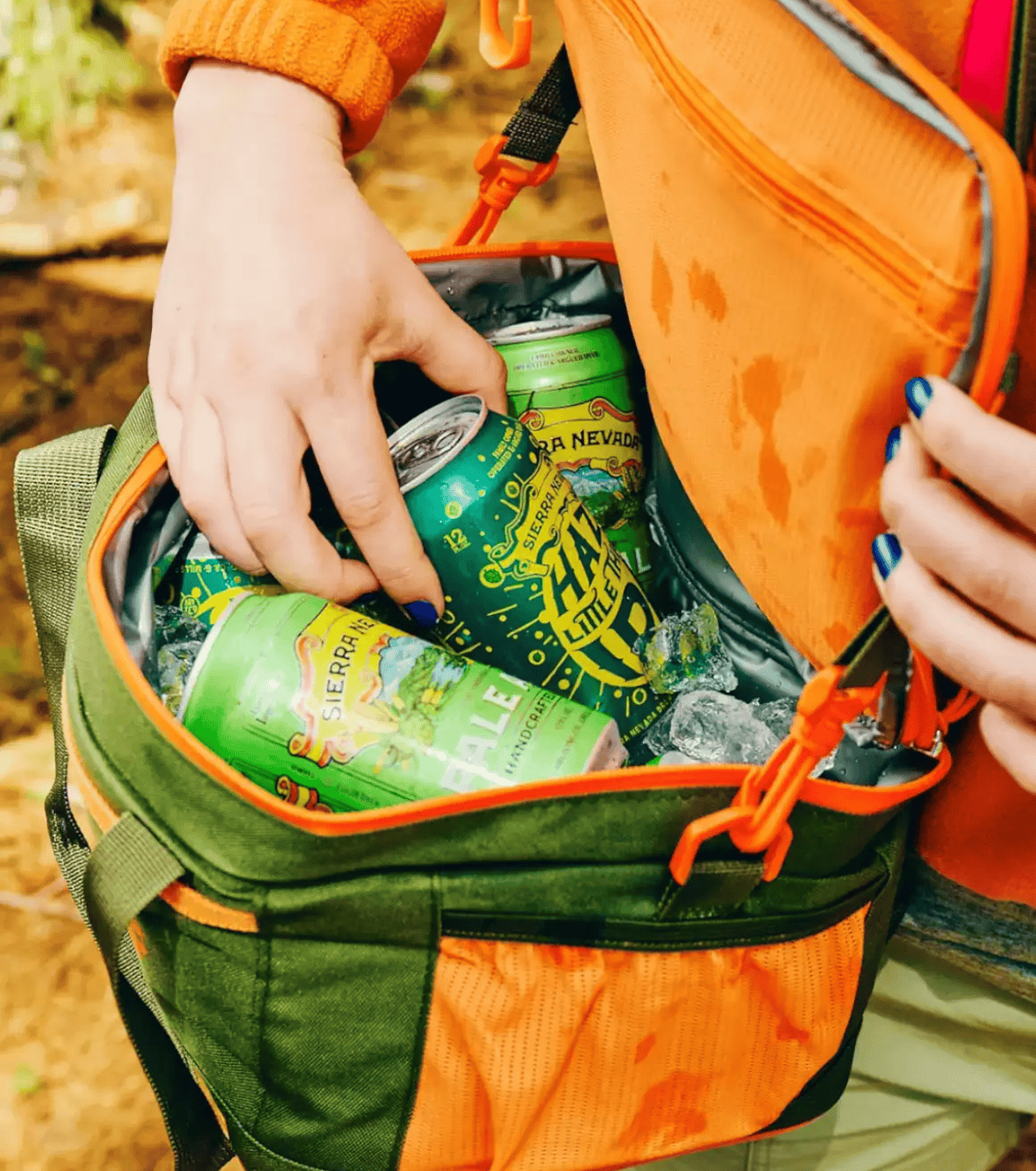 a person grabbing a sierra nevada hazy little thing beer from a cooler