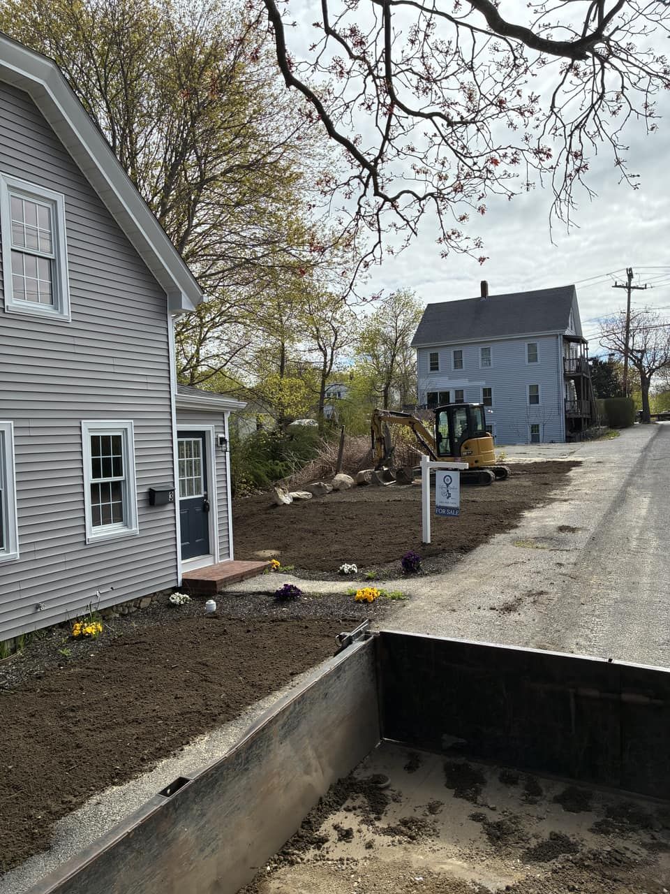 Fresh loam spread and graded for driveway and lawn restoration after septic work Legacy Excavation is a site-work company that provides lawn and driveway restoration in Plymouth, MA