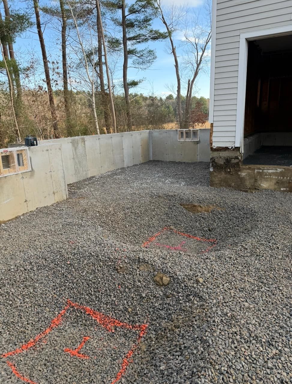 Pier footing excavation through rocky ground on a residential foundation project Legacy Excavation is a site work contractor that digs through ledge and rock for foundations across Southeastern MA