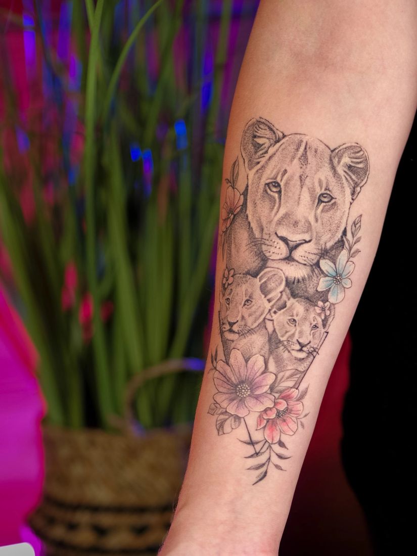 Fine line lioness and cubs forearm tattoo with flowers, by Thomas Palaniuk, Aloha Tattoo Studio Gloucester