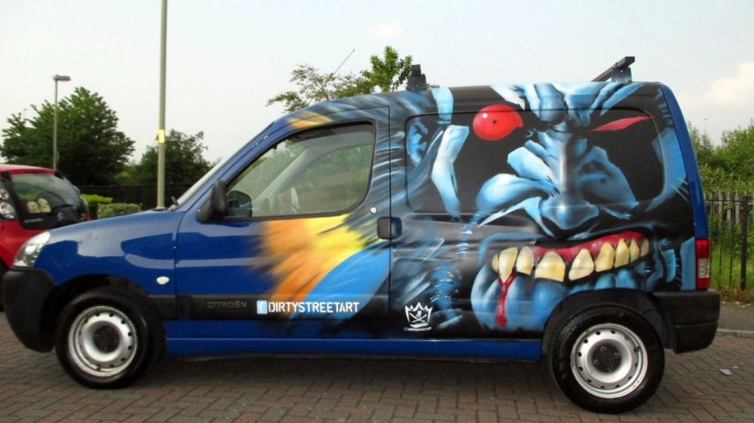 Custom airbrushed van graphics: blue monster face with a red eye and fangs, hand-painted vehicle art by Thomas Palaniuk