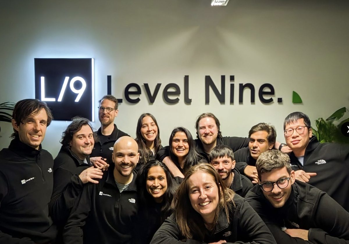 The Level Nine team in front of the illuminated Level Nine logo