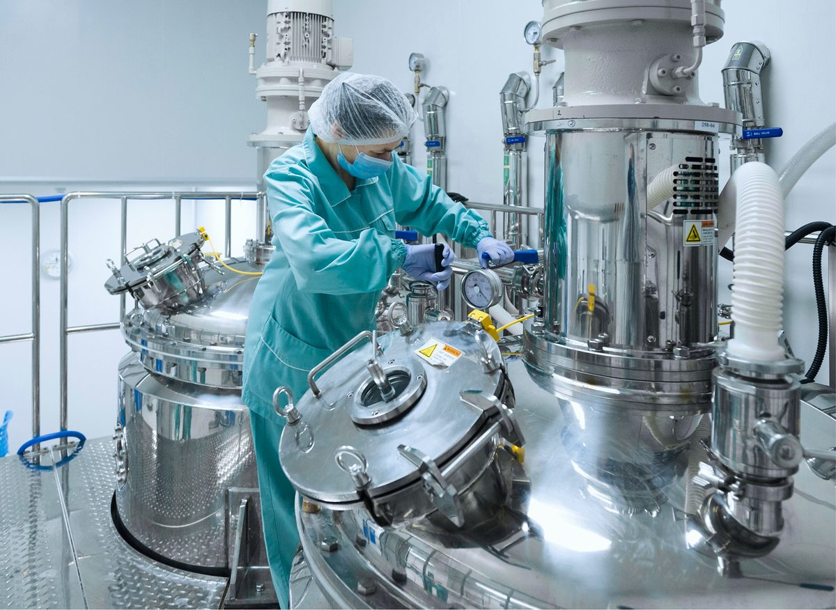 Scientist in a lab coat working at a bench in a bright laboratory