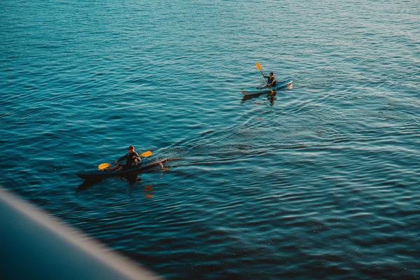 Two kayakers in calm sea water