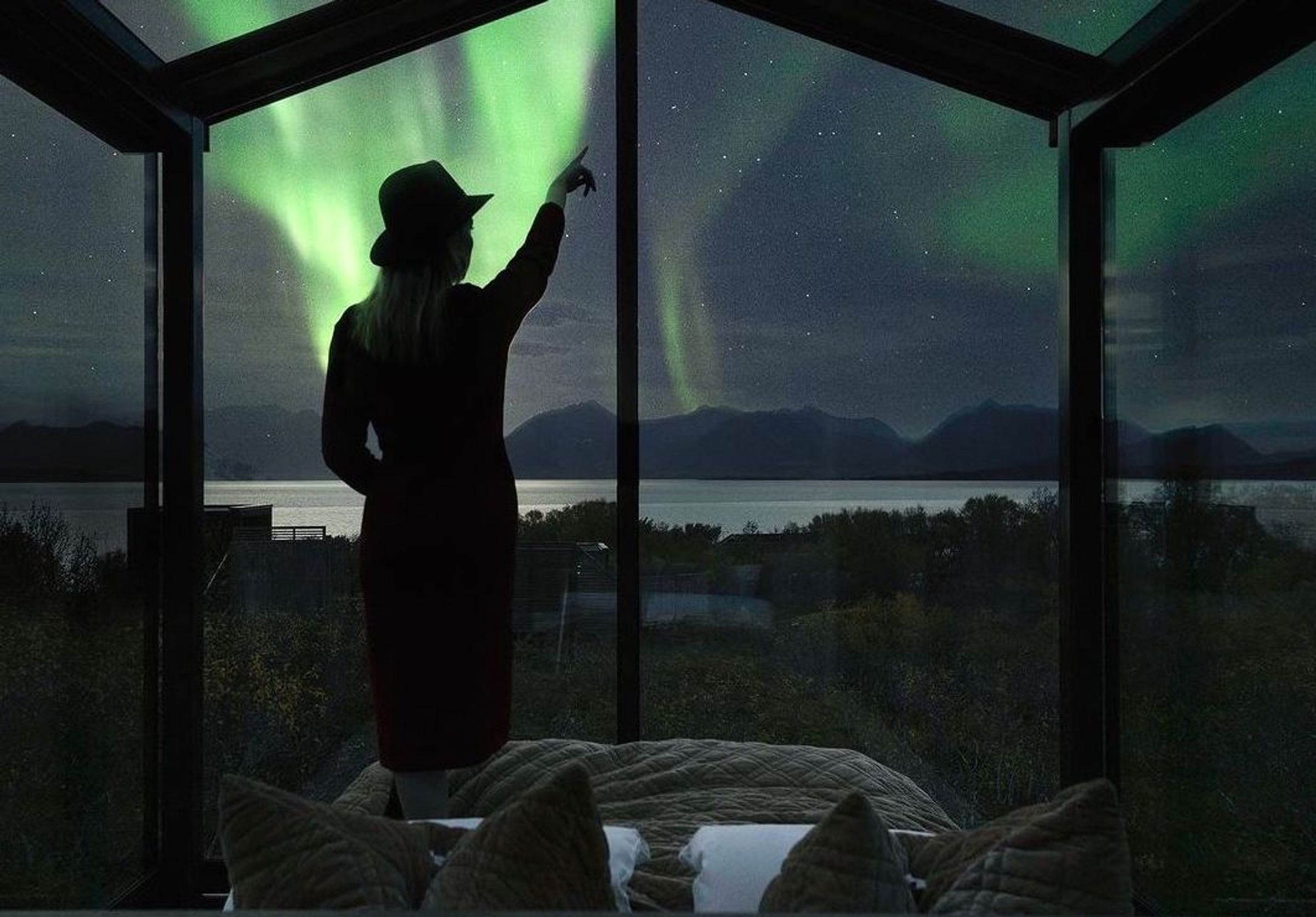 A girl inside a tiny house looking out at the mountains