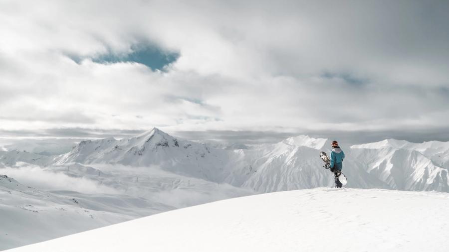 Snowboarder regardant les montagnes dans les Alpes