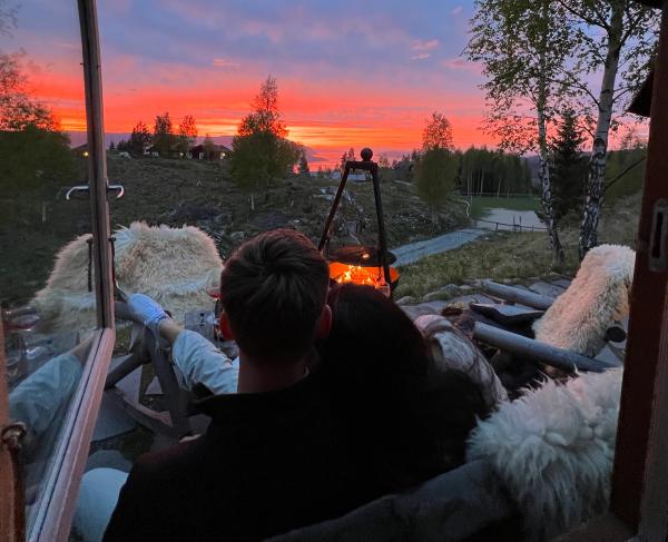 Ein Paar blickt auf den Sonnenuntergang und eine Feuerpfanne