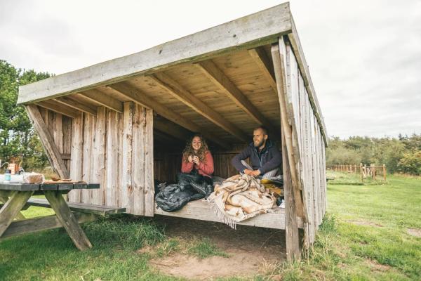 Couple eating breakfast in after camping in a shelter