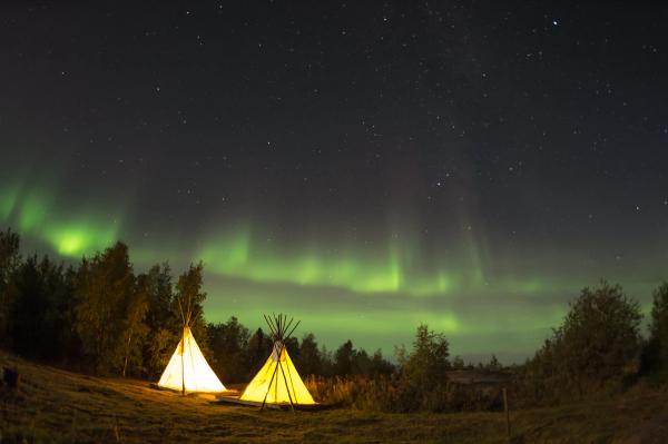 Northern lights aver glamping tents during fall
