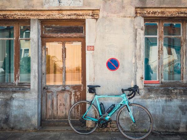 Un vélo de route devant une vieille maison française 