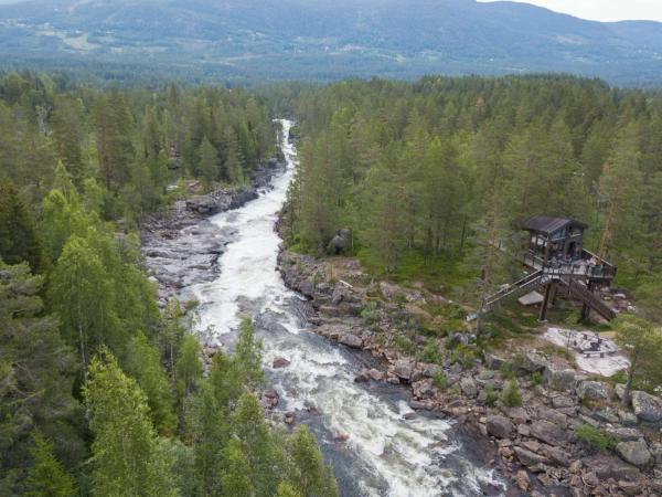 En stor flod som rinner vid en trädkoja i Norge