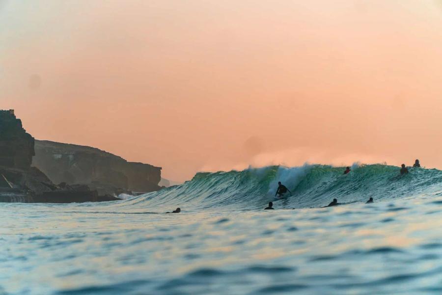 Surfistas a surfar na Ericeira enquanto acampam em Portugal