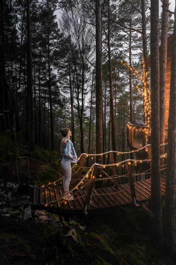 Ein Mädchen betritt ein Baumhaus im magischen Licht