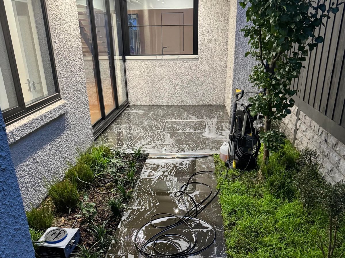 Bluestone paving on May Road, Toorak with ground-in dirt and moss in the joints before cleaning