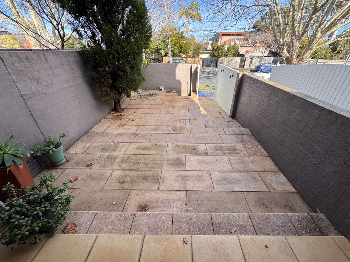 Tiled paving on Were Street, Brighton with dark, dirt-filled grout lines before cleaning