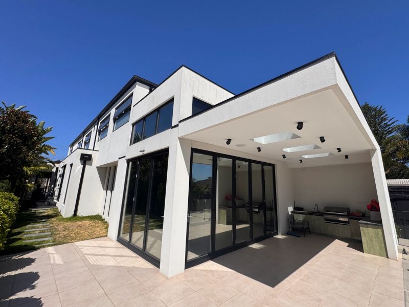 Modern white rendered house on Gleniffer Avenue with black-framed floor-to-ceiling glass