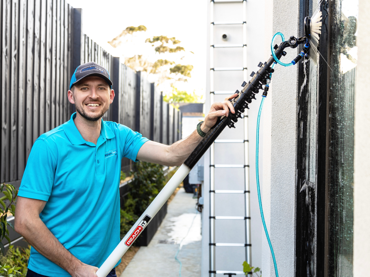 WaterCrew technician cleaning ground-floor windows on a Melbourne home