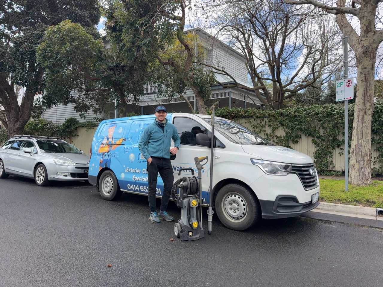 Technician with the WaterCrew van and pressure washer on a tree-lined Hampton street