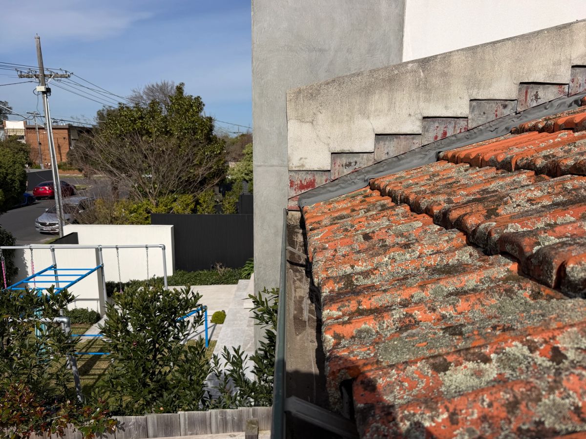 The same Hoddle Street gutter run cleared and draining, the channel empty along its length