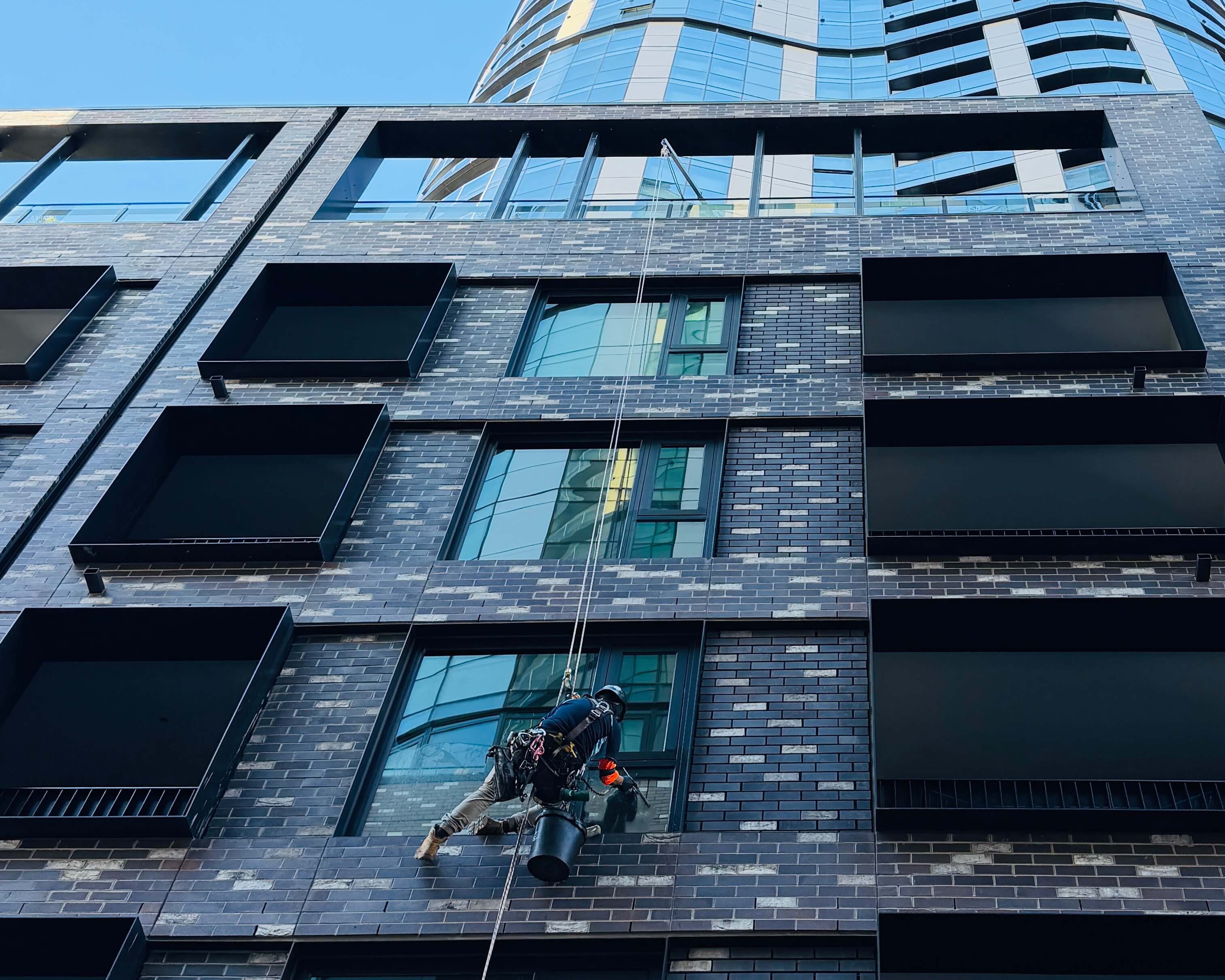 WaterCrew technician on rope access cleaning glass on a Melbourne building