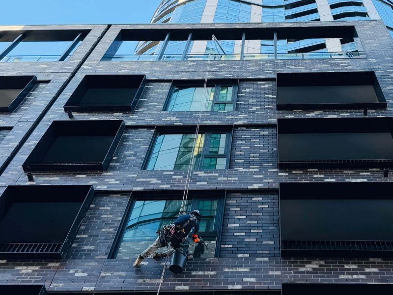WaterCrew technician on rope access cleaning glass on a Melbourne building