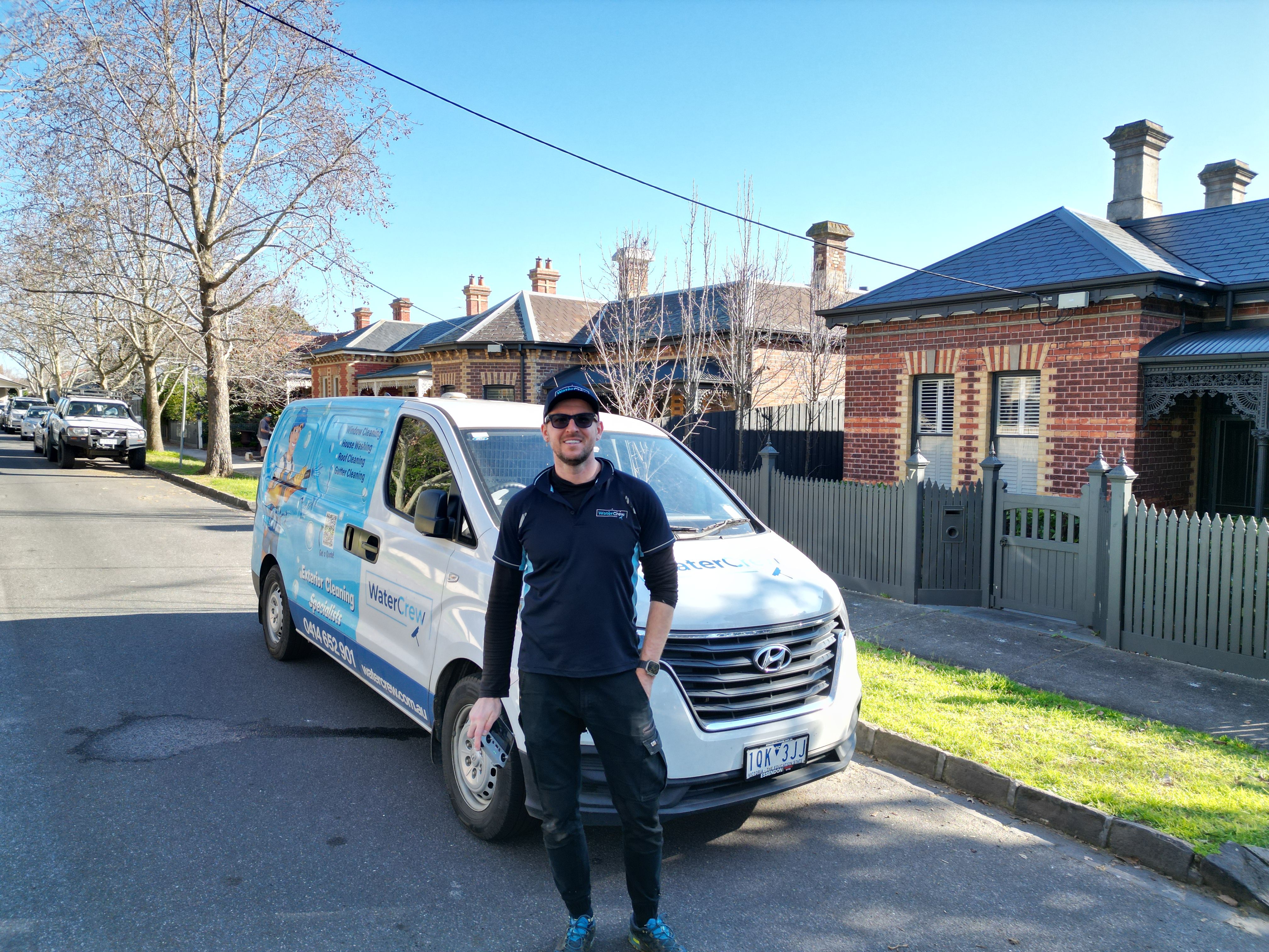 Technician beside the WaterCrew van on a Canterbury street of red-brick Victorian houses