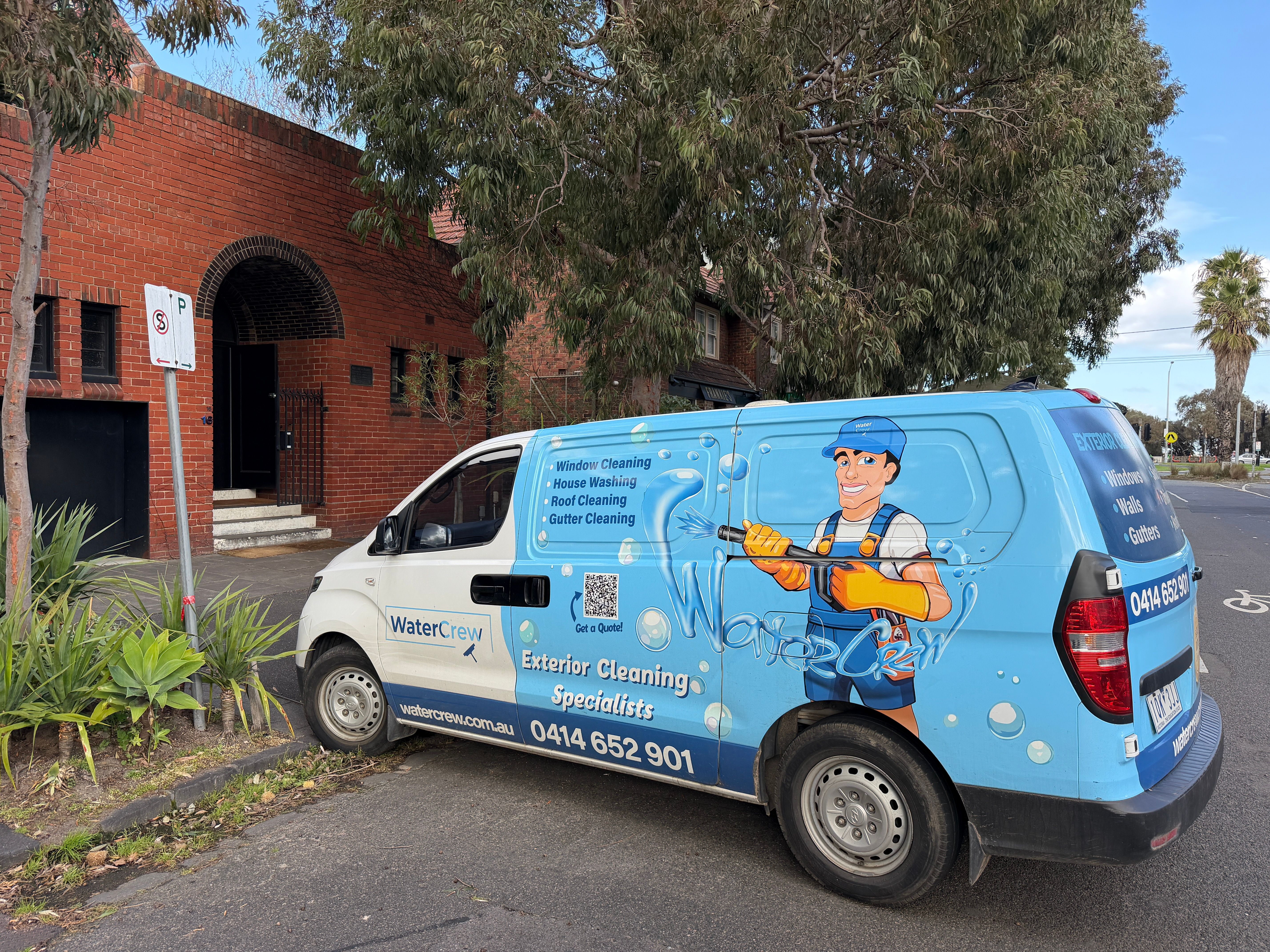 Signwritten WaterCrew van parked outside a red-brick apartment block in St Kilda West